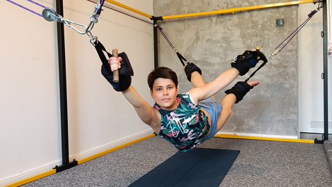 Stretching całego ciała na przyrządzie pravilo - pozycja z nogami w podwieszeniu